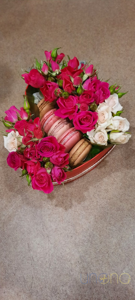 Artisan macarons paired with fresh roses in a heart box