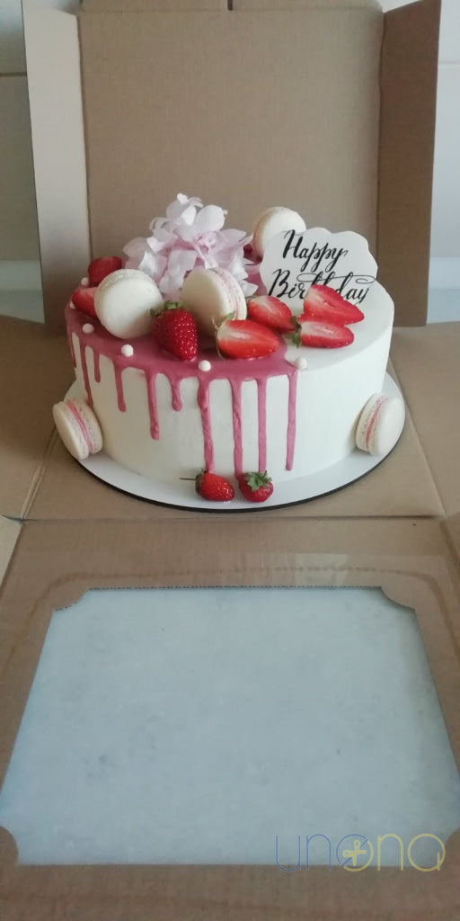 Elegant celebration cake with macarons and berries