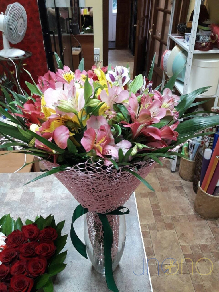 Rustic paper wrapped alstroemerias bouquet with red ribbon