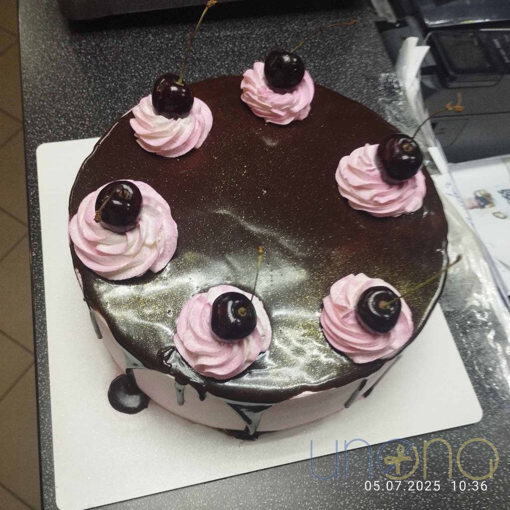 Rich chocolate cherry cake topped with whipped cream and cherries