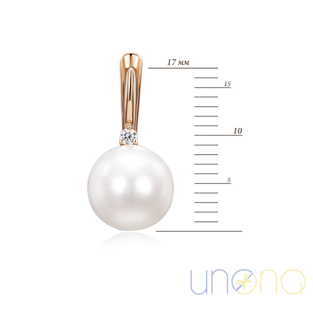 Pearl pendant with gold setting and diamond on a white background with measurement scale.