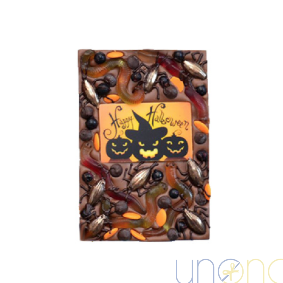 Halloween milk chocolate bar with gummy worms, chocolate bugs, black currants, and Happy Halloween chocolate decoration