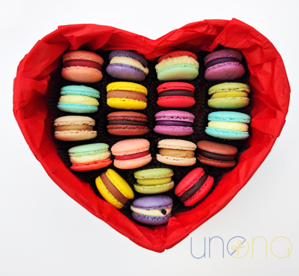Red heart-shaped gift box filled with colorful macarons