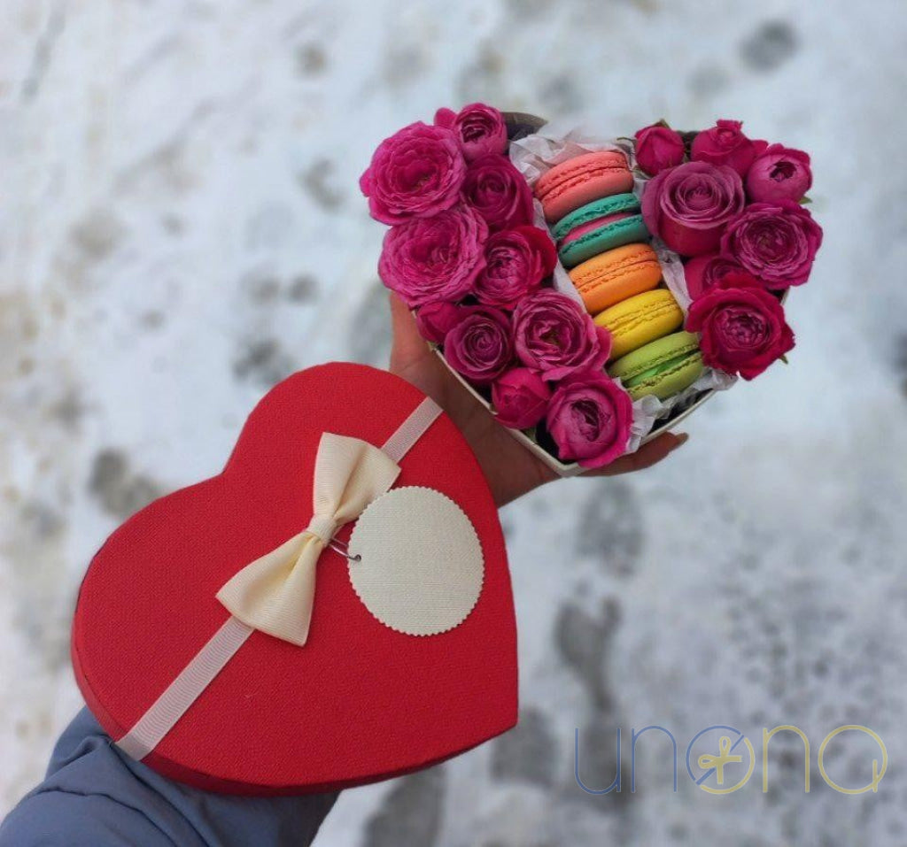 Romantic gift box with pink roses and colorful macarons