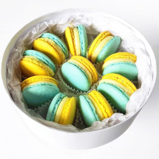 Stand With Ukraine Macarons Gift Box featuring handcrafted blue and yellow French macarons in a premium round gift box