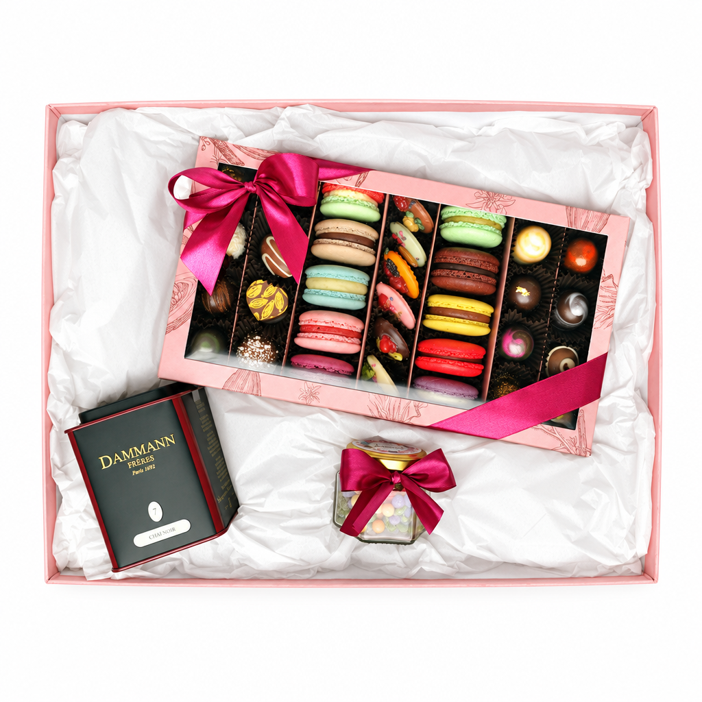 Luxury gift box with Dammann Frères tea, colourful macarons, assorted chocolates and candied flowers, finished with pink ribbons