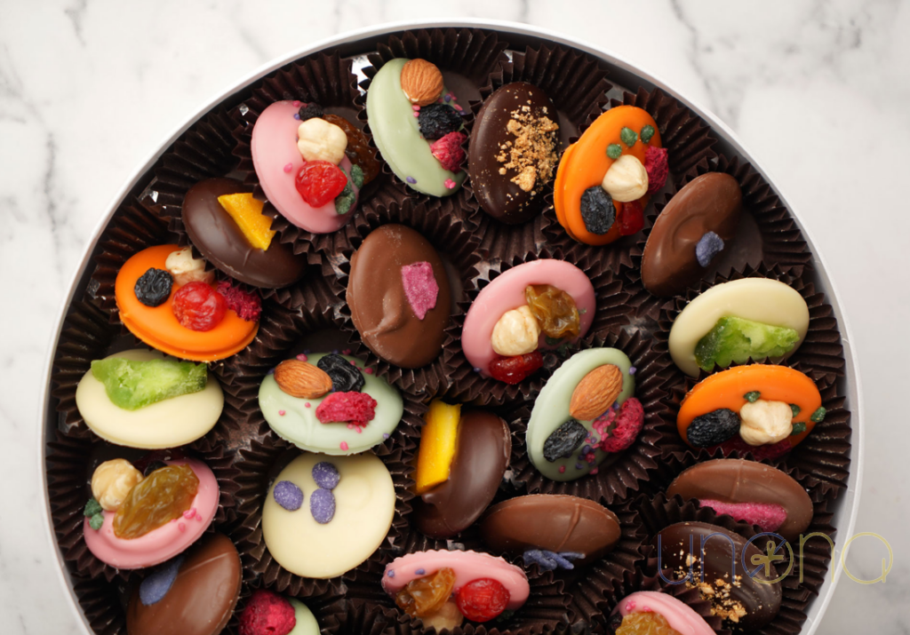 Luxury assortment of handcrafted mini Belgian chocolates decorated with berries, nuts, dried fruits, and crystallized flowers