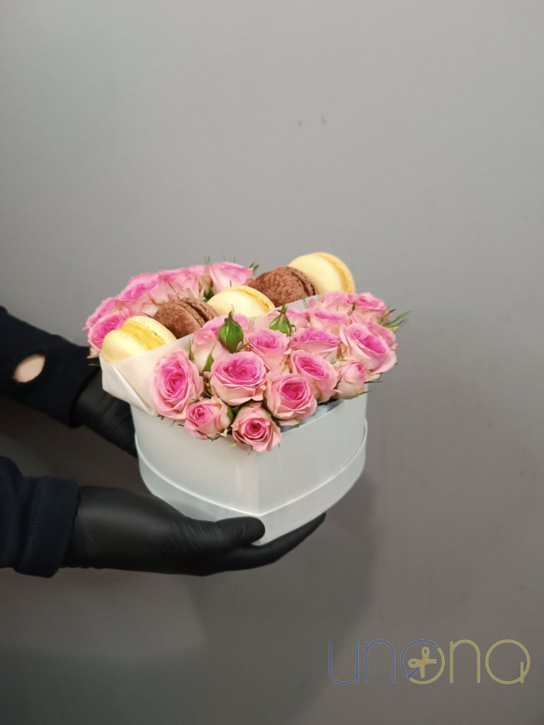 Floral arrangement and macarons in heart-shaped box