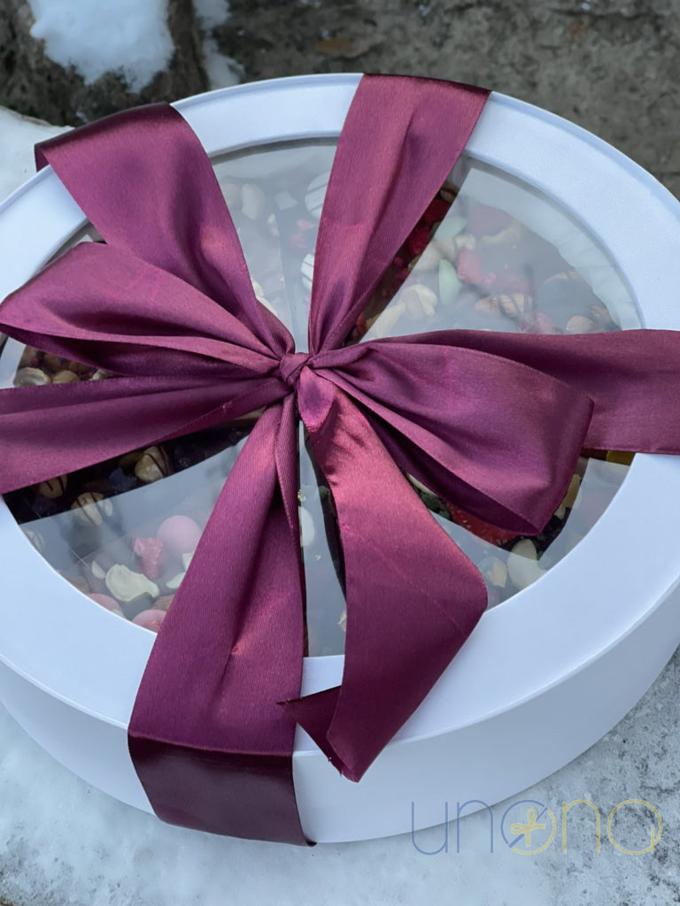 Handmade chocolate pizza decorated with nuts, berries, and dried fruits