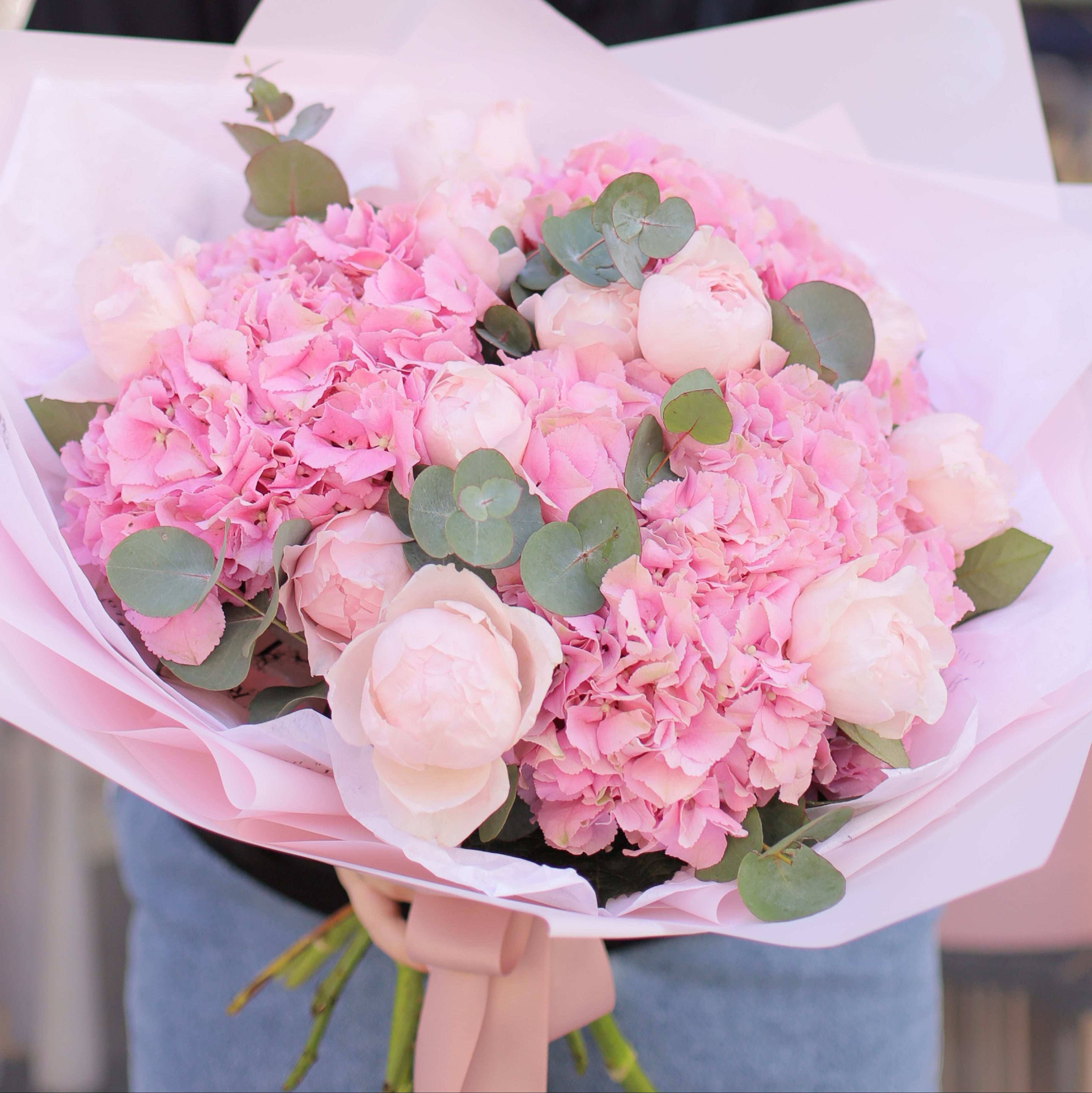 Romantic bouquet with pink hydrangea, blush peonies and eucalyptus wrapped in pastel paper