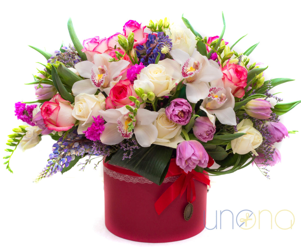 Elegant mixed flower arrangement with roses, orchids, and tulips in a red hat box – flowers delivery in Ukraine