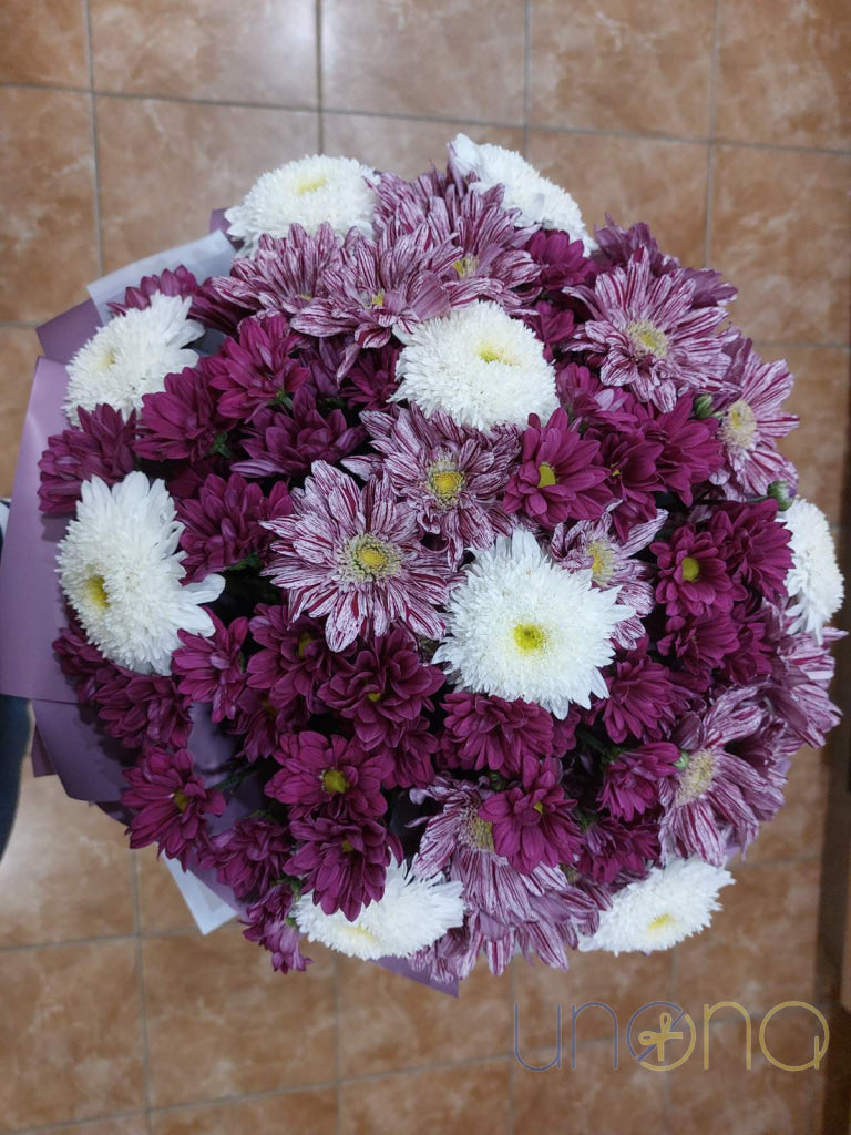 Vibrant aster and chrysanthemum bouquet in lavender, yellow, pink, dark red, and white with elegant wrapping