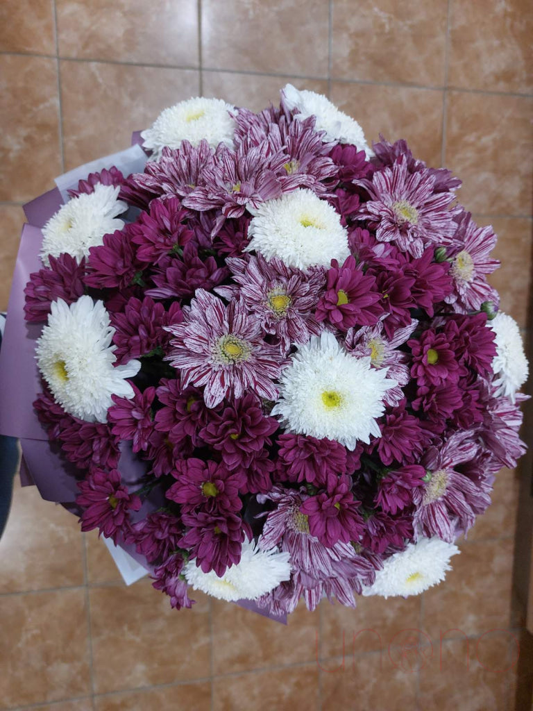 Vibrant aster and chrysanthemum bouquet in lavender, yellow, pink, dark red, and white with elegant wrapping