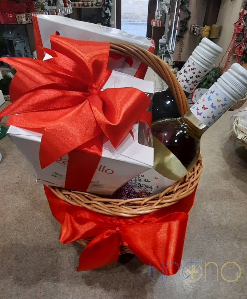 Decorative wicker basket with red wine, white wine and luxury chocolates