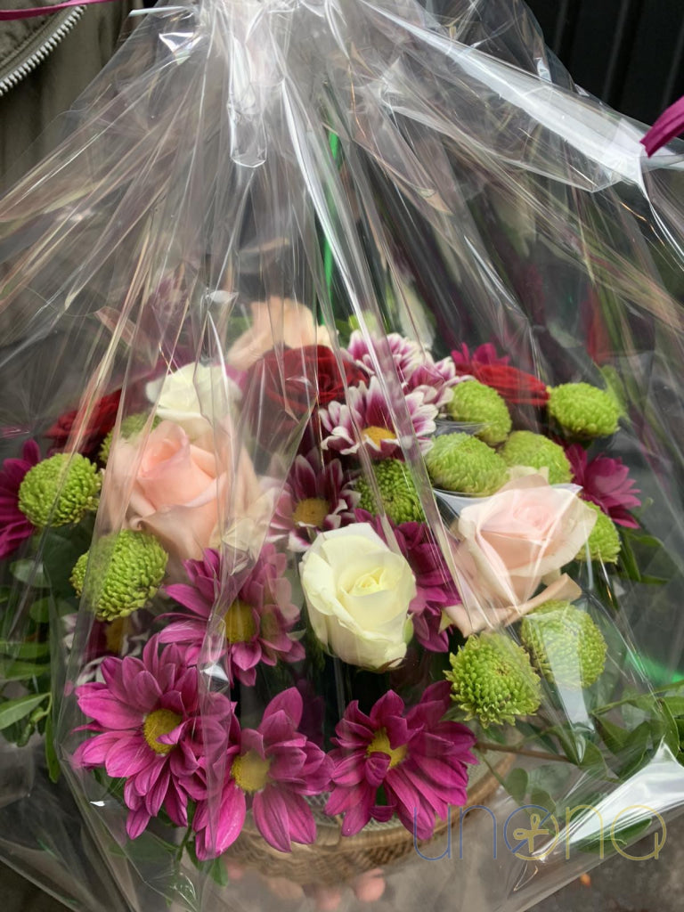 Roses and orchids arranged in a wicker flower basket