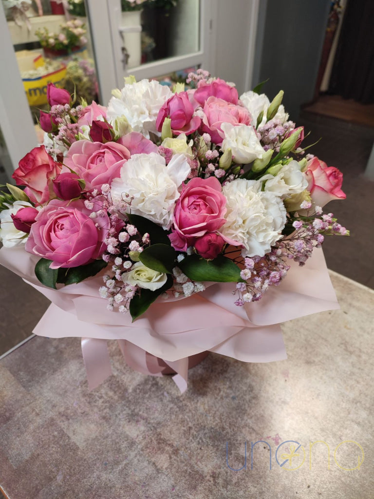 Elegant boxed bouquet with pastel roses, carnations and winter greenery