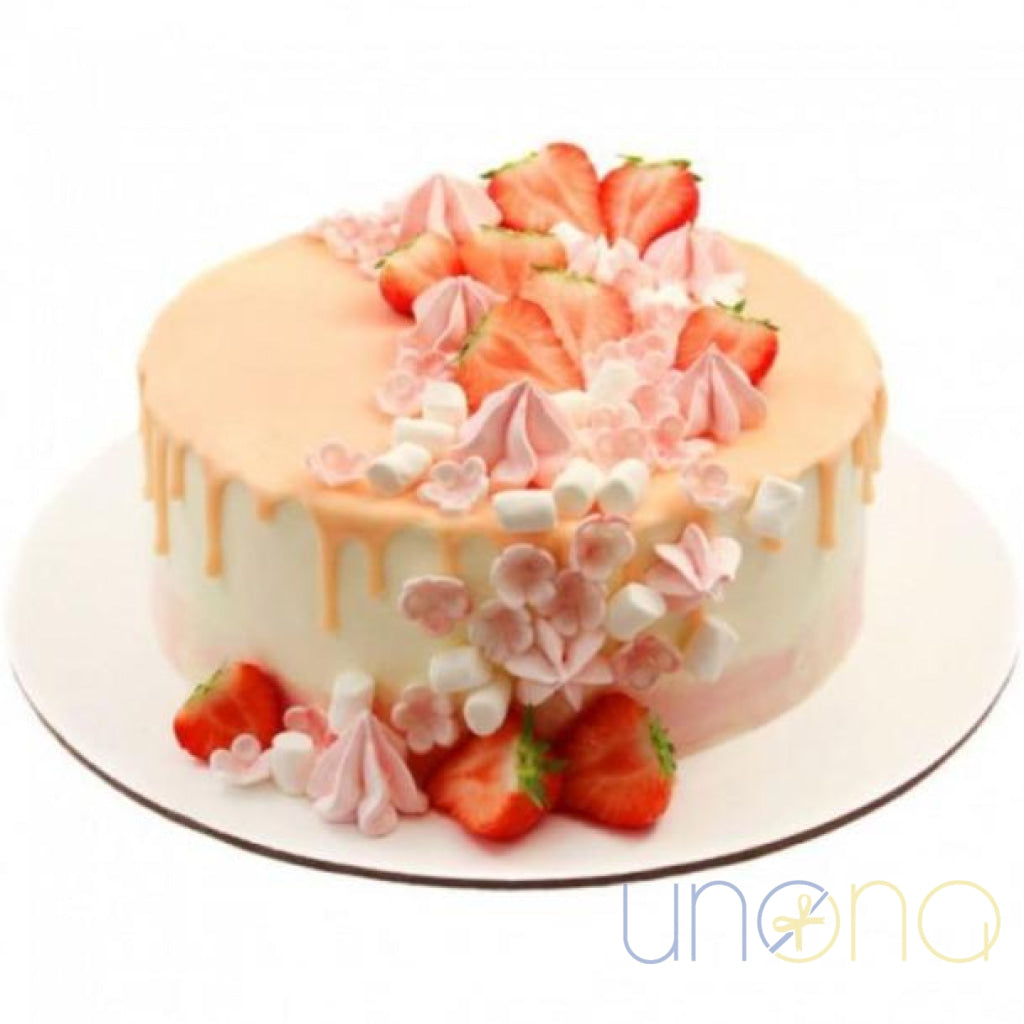 Strawberry cake decorated with fresh strawberries, buttercream kisses, and pink chocolate drip