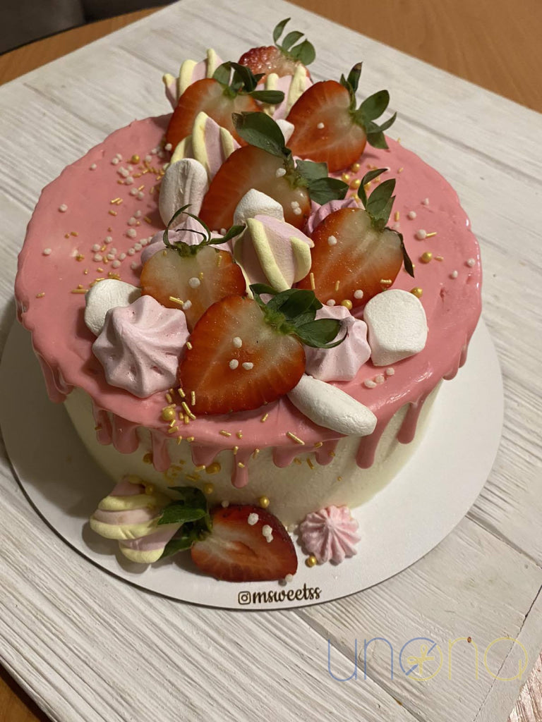 Strawberry cream cake with pink chocolate drip and fresh berries